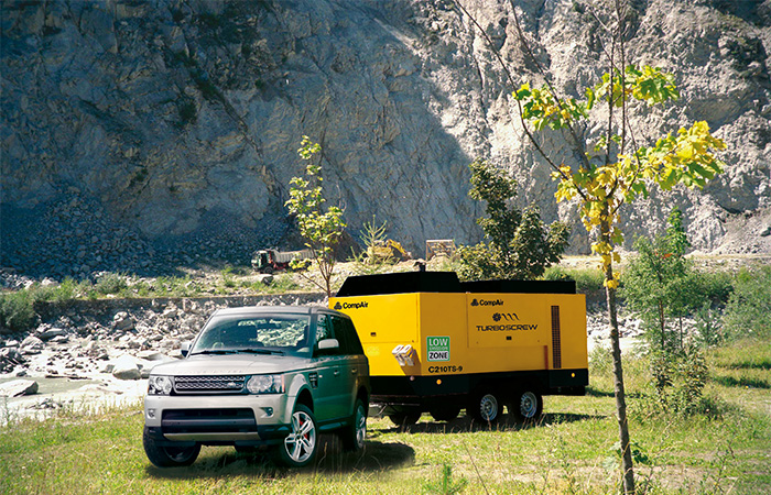 Turboscrew large portable air compressor being towed by a car